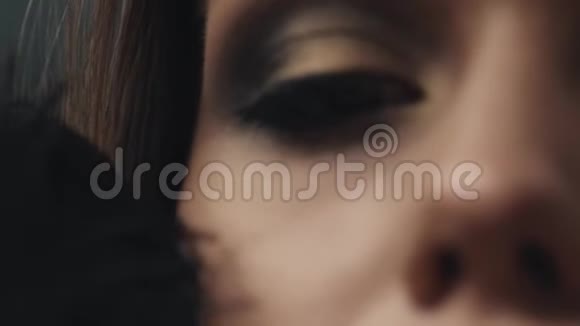女人的脸部化妆品的护肤品化妆品嘴唇的哑光唇膏轻轻抚摸的黑色羽毛视频的预览图
