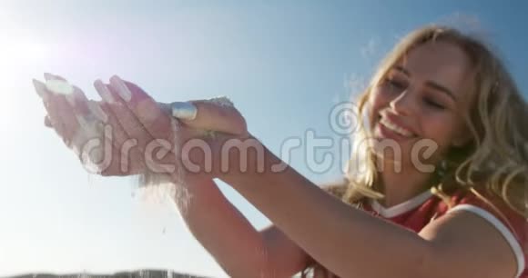 女人蹲在海滩上视频的预览图