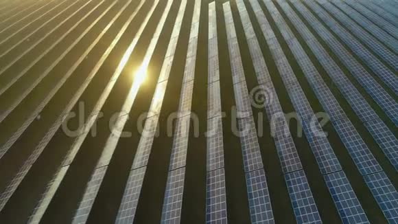 日落时蓝色光伏太阳能电池板的大场空中观景台飞行便道视频的预览图