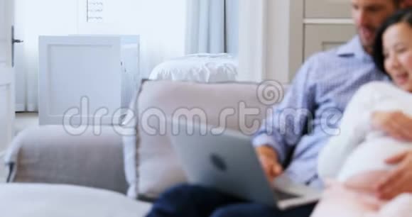 在客厅4k的床上使用笔记本电脑的孕妇视频的预览图