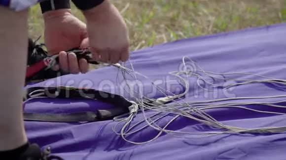 近距离拍摄一个跳伞教练的包装准备跳跃的设备降落伞的带子视频的预览图