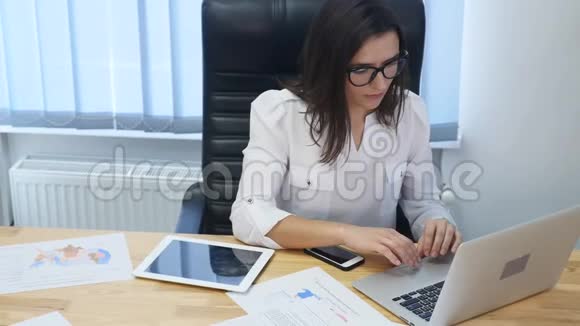 商业过度工作截止日期愿景和人的概念戴眼镜的疲惫的女商人戴着笔记本电脑视频的预览图
