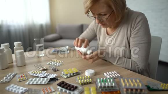 老年妇女从所有瓶子里服用胶囊自我治疗药物成瘾视频的预览图