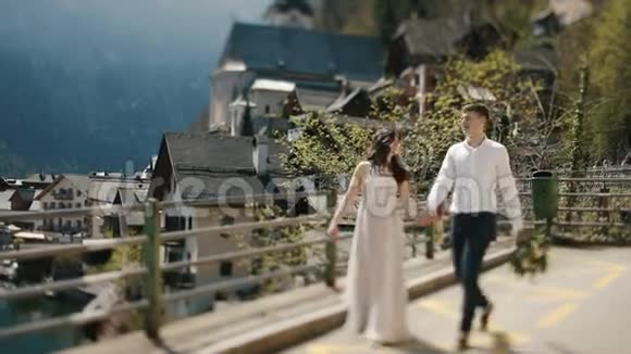 这对穿着古装的夫妇走在桥上背景是山里的老城视频的预览图