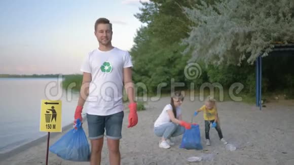 环境保护戴橡胶手套的快乐志愿者男性肖像垃圾袋靠近指针标志视频的预览图