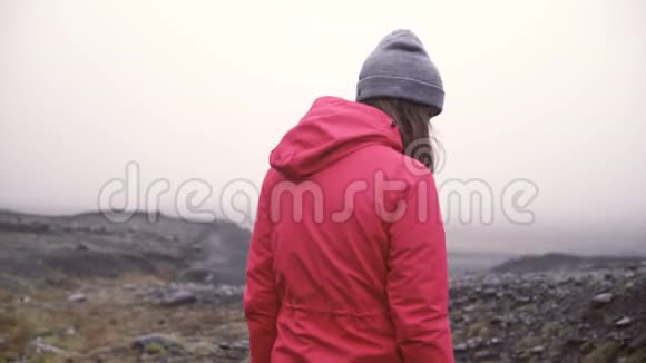 年轻女子在岩石山徒步旅行的后景独自旅行的女性独自探索冰岛穿过沼泽视频的预览图