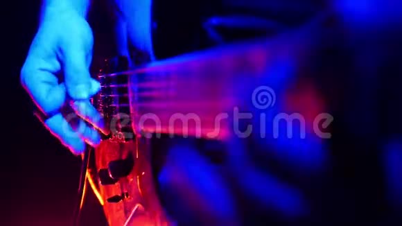 吉他手用明亮的霓虹灯弹吉他烟雾机开始工作房间里充满了烟雾视频的预览图