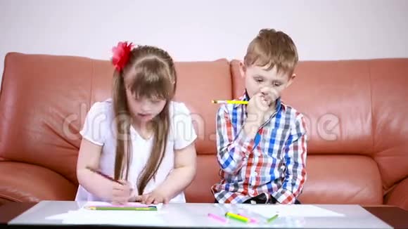 两个可爱的快乐孩子在玩学校用蜡笔画画唐氏综合症的女孩残疾人康复视频的预览图
