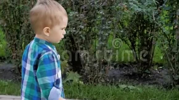 2岁赤脚幼儿男孩在公园草地上奔跑的慢动作视频视频的预览图
