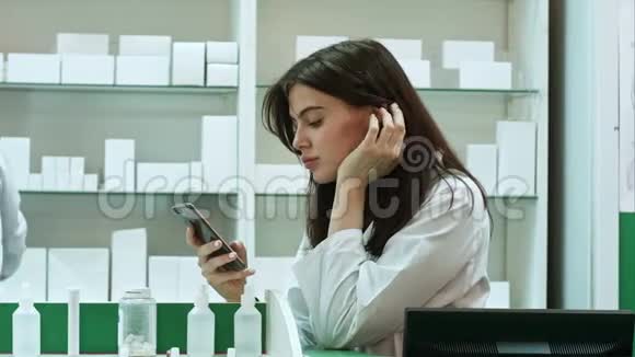 无聊的女药剂师在药房使用手机视频的预览图