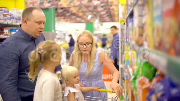 快乐的一家人在购物一家人穿过超市家人在超市购物家庭视频的预览图