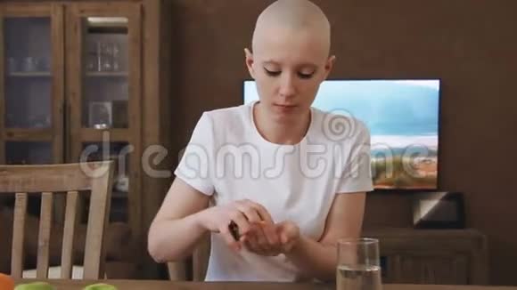 癌症病人的女人坐在桌边吃药视频的预览图