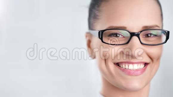 在白色的工作室里戴着眼镜的美丽商务女性面带笑容视频的预览图