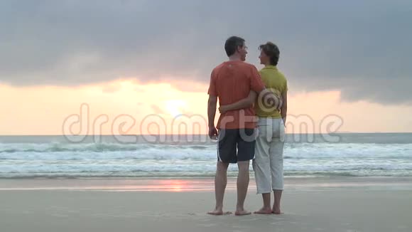 一对夫妇在海滩上看日出视频的预览图