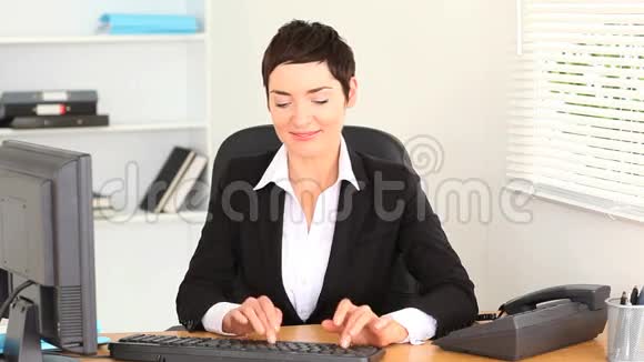 布鲁内特女士在笔记本电脑上打字并接电话视频的预览图