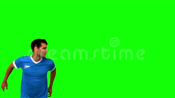一个漂亮男人在绿幕上踢足球视频的预览图