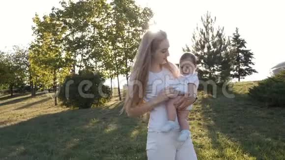 在耀斑日落时母女的缓慢运动幸福家庭的概念视频的预览图