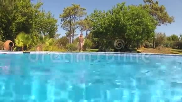 男孩跳入游泳池然后在水下游泳摄像视频的预览图