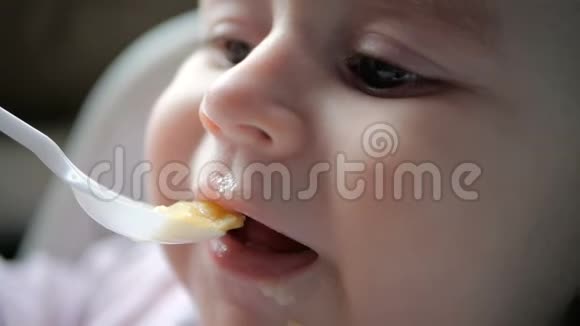 小宝宝慢吞吞地在室内用塑料勺子吃粥视频的预览图