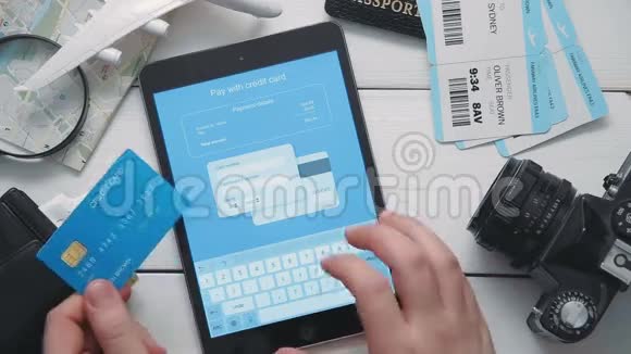顶级旅行者用数字平板电脑和信用卡在白色的办公桌上在线支付机票视频的预览图
