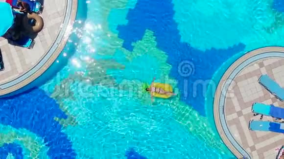 一个带橡胶圈的女孩在游泳池里视频的预览图
