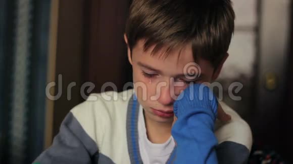 坐在书桌前哭泣的小男孩他的眼泪视频的预览图