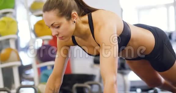 受过良好训练的女人在健身操垫上做俯卧撑视频的预览图