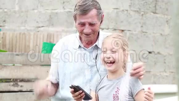 快乐的祖父和孙女拥抱在院子里笑视频的预览图