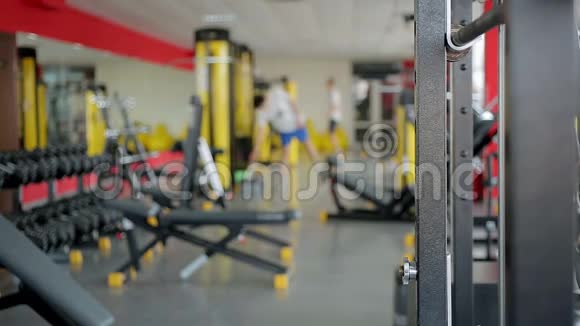 使用运动器材在健身俱乐部健身房锻炼的离焦人群视频的预览图