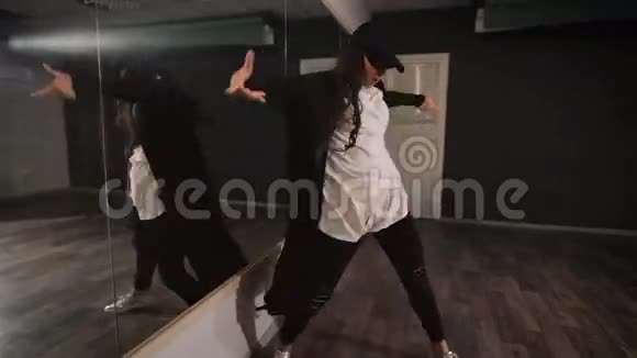 年轻的女舞者穿着白色衬衫黑色裤子和黑色帽子展示爵士乐现代舞女孩在跳舞视频的预览图