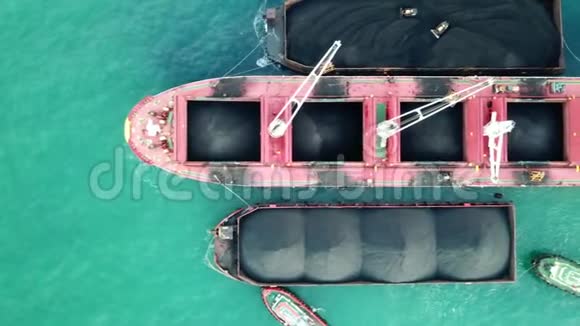 大型红母船在海上货运港散装船上装载煤炭高空俯视图视频的预览图