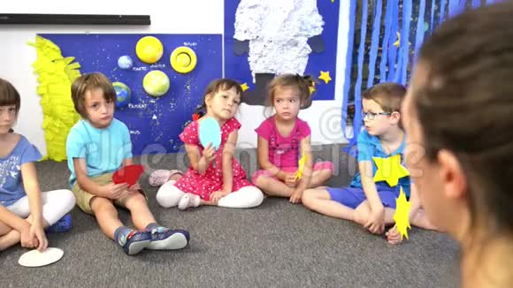 在幼儿园被孩子们包围的教育家视频的预览图