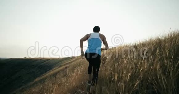 跑步运动员在日落时慢跑男子慢跑训练马拉松跑在山上的轮廓与视频的预览图