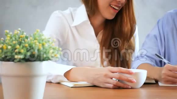 女商人用手机在木桌上写报告亚洲女人用电话和咖啡视频的预览图