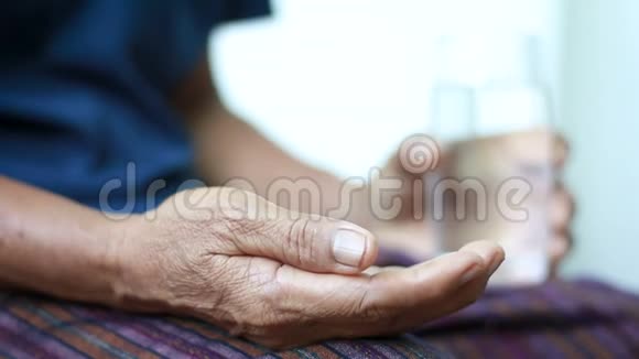 年轻女子的手拿着药片药放到老年妇女的手中老母亲和你的保健理念视频的预览图