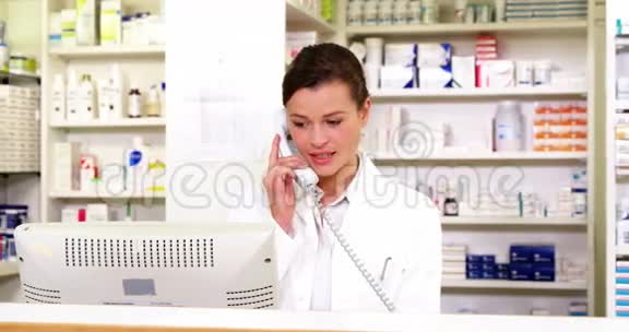药剂师站在柜台边打电话视频的预览图