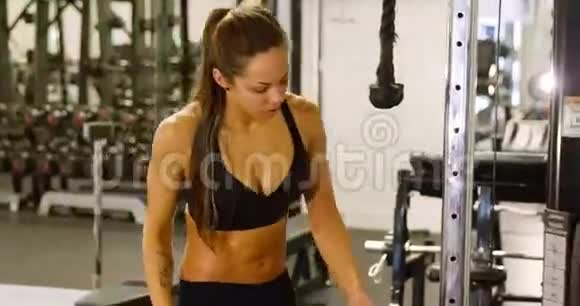 积极的女性锻炼三头肌拉索机在健身房视频的预览图