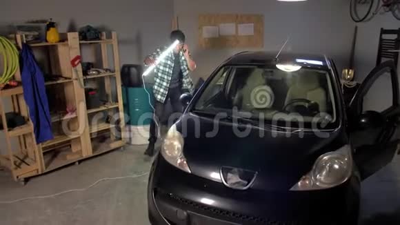 一个人用灯检查一辆车视频的预览图