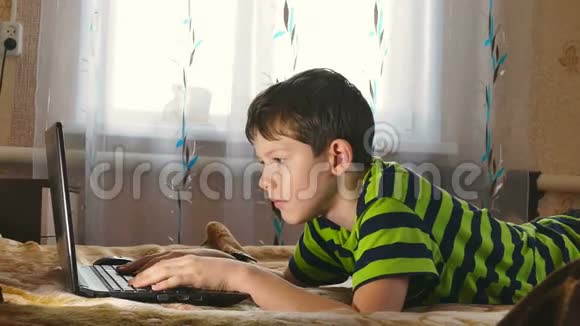 男孩的笔记本电脑正在上网躺在床上视频的预览图