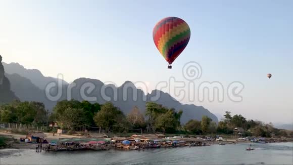 一个五颜六色的大气球飞过老挝的河流视频的预览图