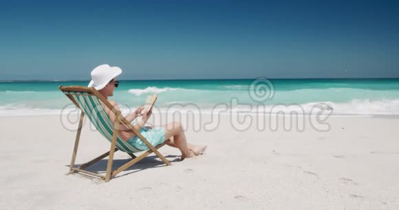 在海滩上看书的人视频的预览图