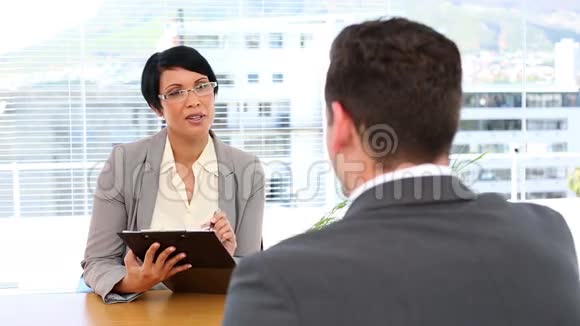 女商人在办公桌前采访男人视频的预览图