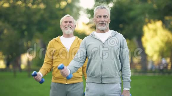 活跃的退休朋友举起哑铃健身训练公园健康老化视频的预览图