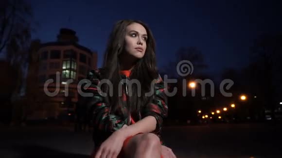 女孩晚上坐在城里视频的预览图