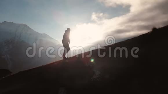 一个人在山的边缘行走的史诗般的空中景象就像一个美丽的轮廓视频的预览图