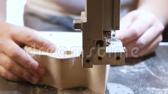 工匠正在用锯条从木头上切割一个木制工件特写双手视频的预览图