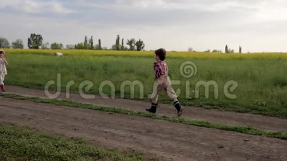 可爱的孩子们互相拥抱结识朋友绕着田野路跑慢动作男孩和女孩都很高兴见面视频的预览图