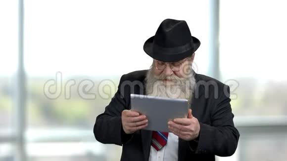 兴奋的老人拿着平板电脑视频的预览图