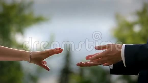 新娘和新郎在日落时互相握手慢动作视频的预览图