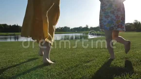 母子在草地上奔跑的特写腿视频的预览图